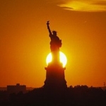 Le Soleil se couchant derrière la Statue de la Liberté est un peu plus lointain qu'a l'accoutumée le 4 juillet